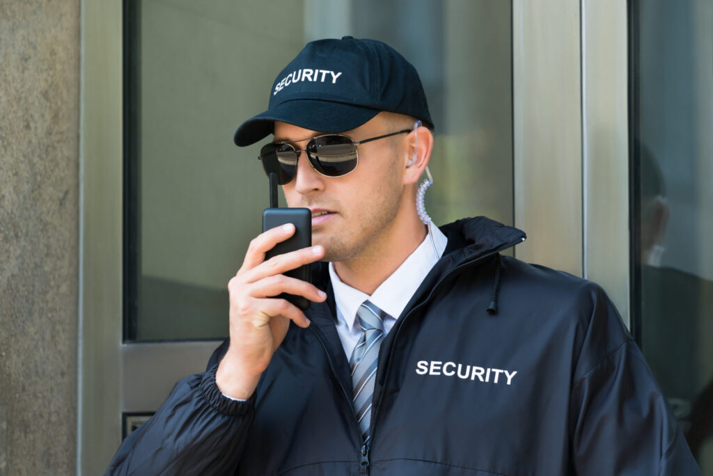 Portrait Of Young Security Guard Using Walkie-talkie Radio